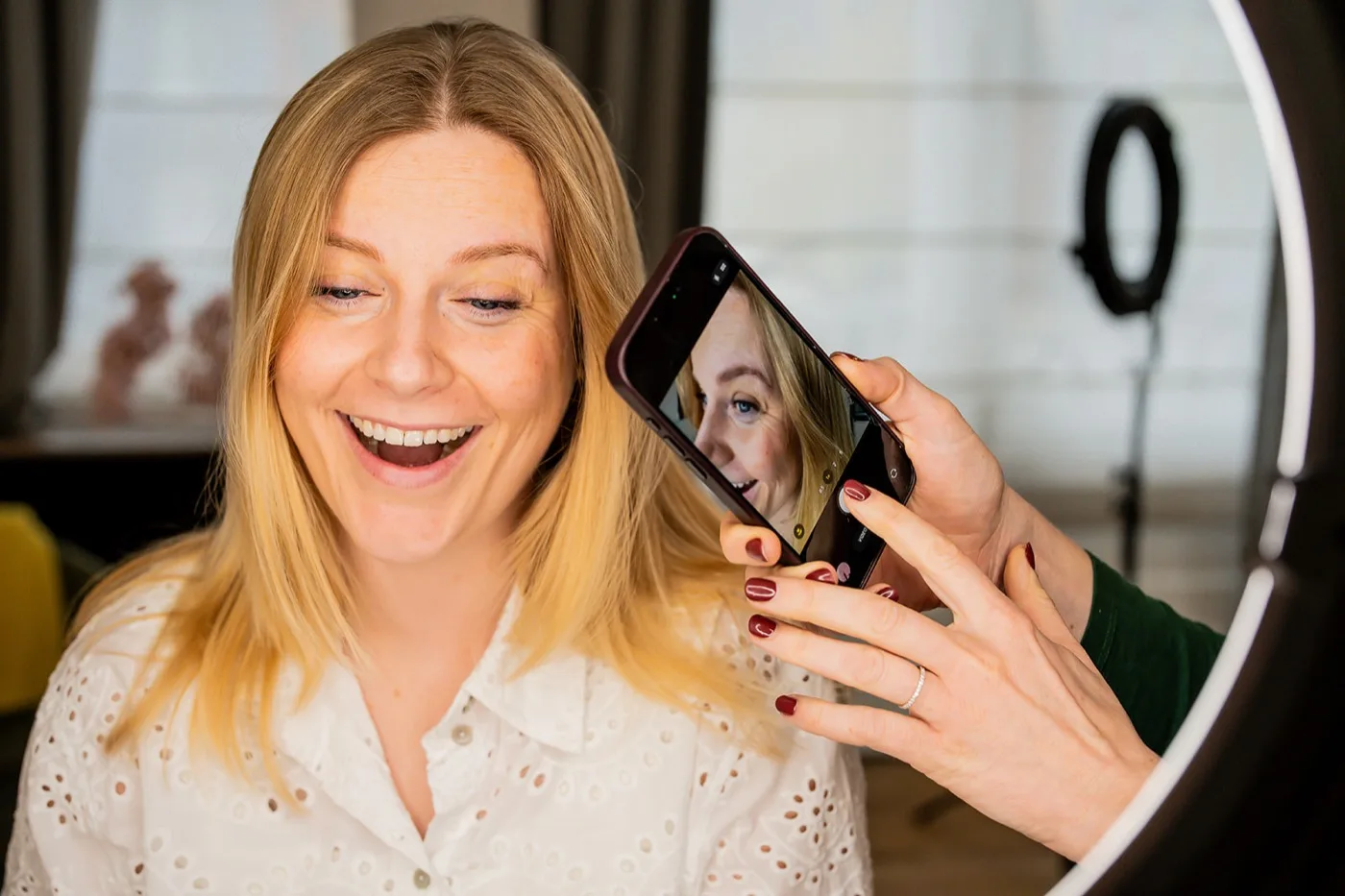 Klante bekijkt lachend het resultaat van haar lip blush behandeling